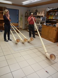 demonstrating playing an alphorn
